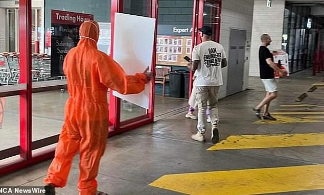 Members held signs (pictured) outside Bunnings stores calling for a ban on workbenches containing high levels of crystalline silica