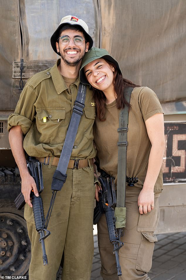 Ben, 24, from Tel Aviv, with Noa, 23, restaurant manager from Batan Hefer, relaxing with the automatic rifles around them as they prepare for war