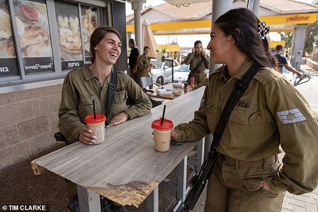 Alice, 20, with Ali, 21, both from Jerusalem, giggle while having a drink at a local coffee shop