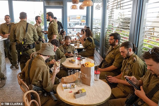 All reserve forces have served in the Israeli army for at least 32 months (pictured, soldiers are relaxing in Tel Aviv