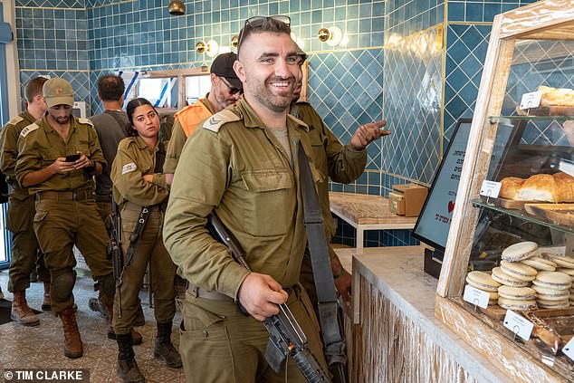 The volunteers must put their normal lives on hold when called to serve (reservists pictured taking a break from their duties ahead of an expected ground invasion of Gaza)
