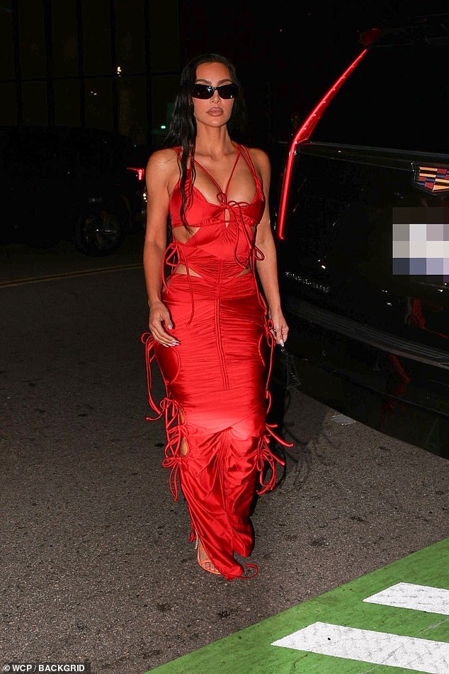 Flash of flesh: Kim's dress showed off her famous curves through countless cutouts that cascaded down the sides