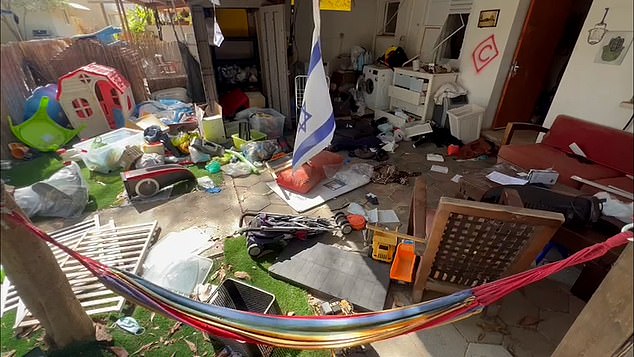 In one house there is a colorful children's playhouse in the garden, surrounded by toddler toys.  An Israeli flag dangles among the rubbish