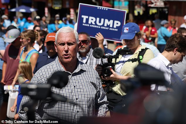 A Trump-supporting heckler makes his presence known as former Vice President Mike Pence speaks to the media at the Iowa State Fair