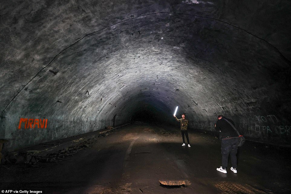 Now there are plans to open the huge complex, which is just a stone's throw from southern Europe's busiest national park, Europe's Plitvice Lakes, to tourists (visitors Angelo Virag (R) and Mario Garbin (L) take pictures of the dark tunnels of Zeljava)