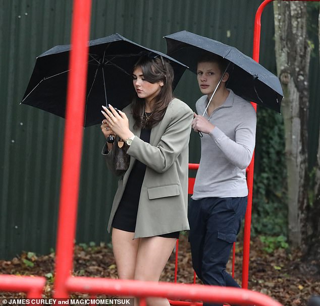 More than friends?  The model, who supported older brother and EastEnders actor Bobby, 20, cuddled up with a companion under their umbrellas as they braved the horrendous weather