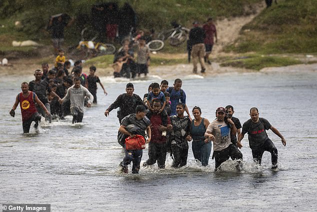 Immigrants wade through the Rio Grande as they enter the United States from Mexico in Eagle Pass, Texas on September 27, 2023
