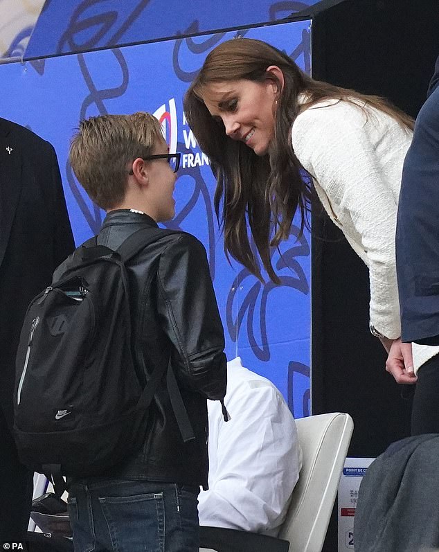 Princess of Wales meets a young fan in the stands during half-time