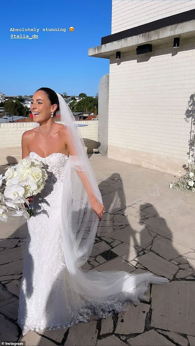 She added a flowing veil attached to dark brown hair, styled into a sleek bun