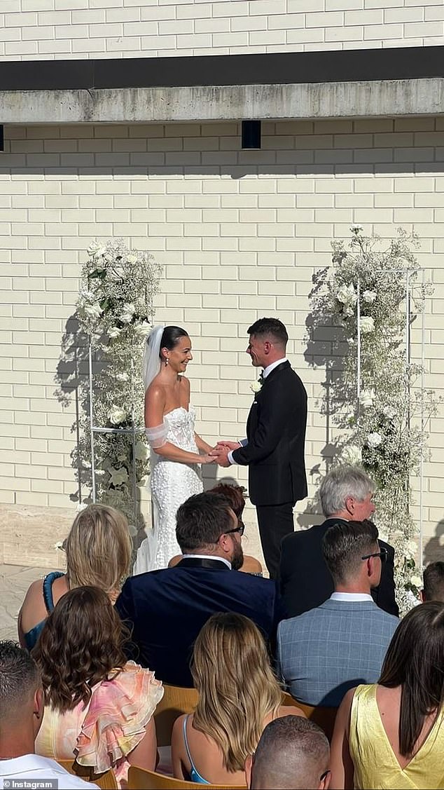 At the altar they were flanked by white flowers