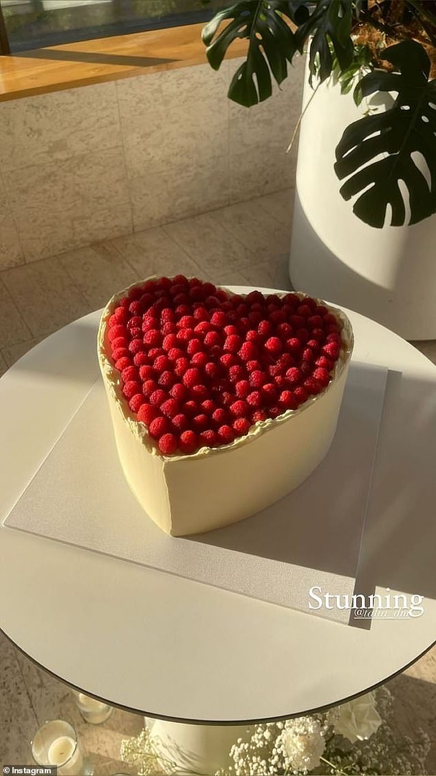 The newlyweds cut their heart-shaped white chocolate cake with raspberry topping