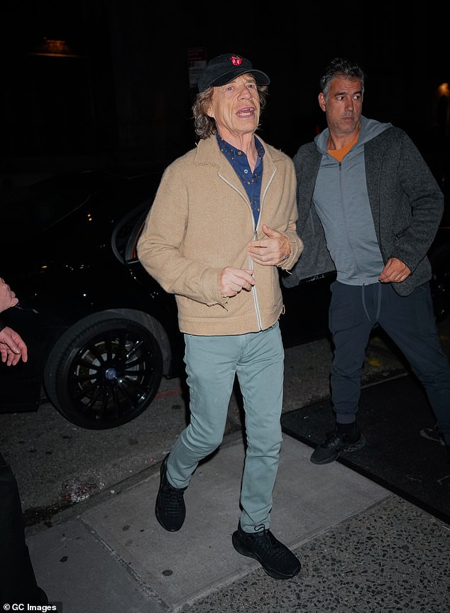 Rock'n'roll: Mick Jagger, who was also in attendance, rocked a blue shirt and camel jacket, with light green trousers and black trainers