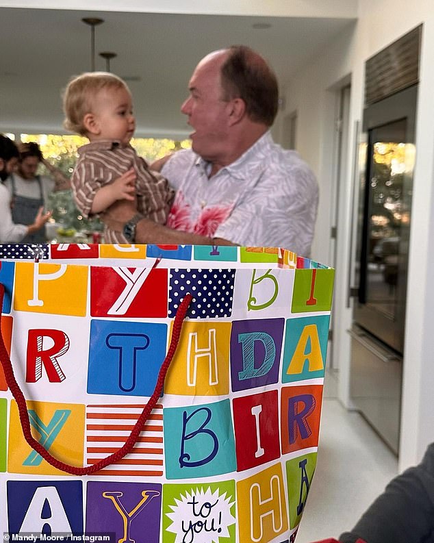 Have fun: The birthday boy seemed to have a great time at the Curious George themed party at their home, which was decorated with blue and orange balloons