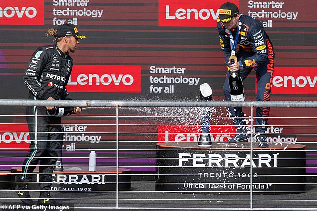 Mercedes' Hamilton and Red Bull Racing's Dutch driver Max Verstappen celebrate on the podium, just hours before the British driver was disqualified