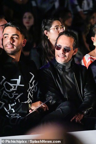 Rocker chic: The actor also wore bleached gray jeans and sported square aviators as he sat in the front row with his friend