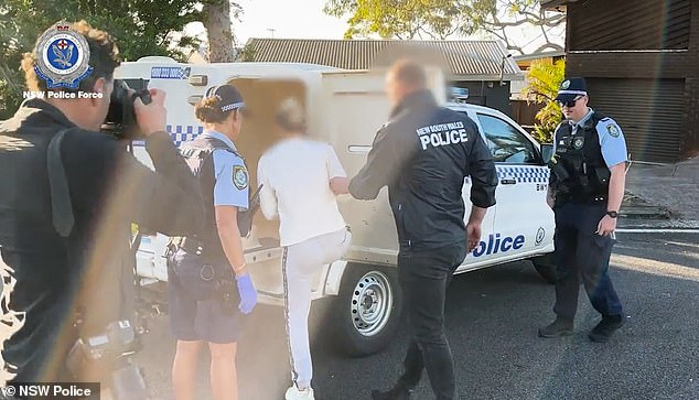 Police raided the TV star's Umina Beach home before 7am on Friday and handcuffed her before placing her in a police van (above)