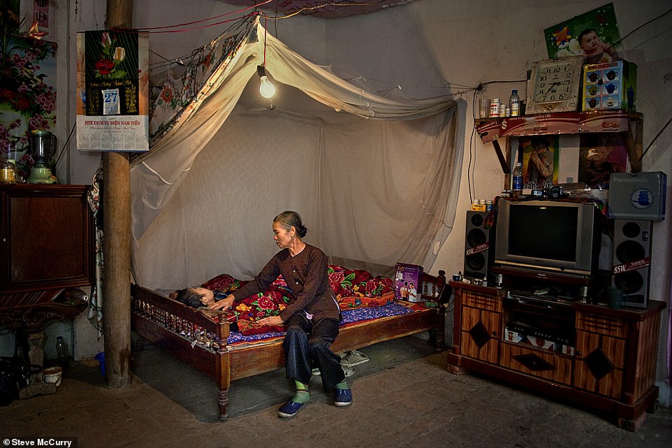 This poignant photo, taken in Vietnam in 2007, shows a sick man's aunt helping to care for