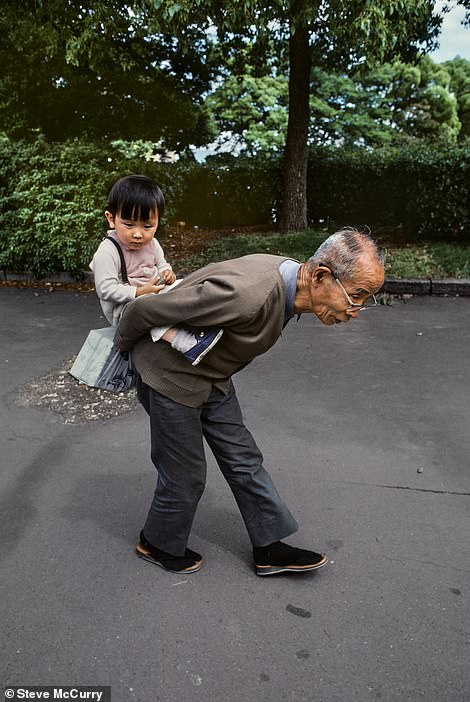 This heartwarming photo from 1985 shows a grandfather carrying his grandson on his back.  It was captured by McCurry in Tokyo, Japan