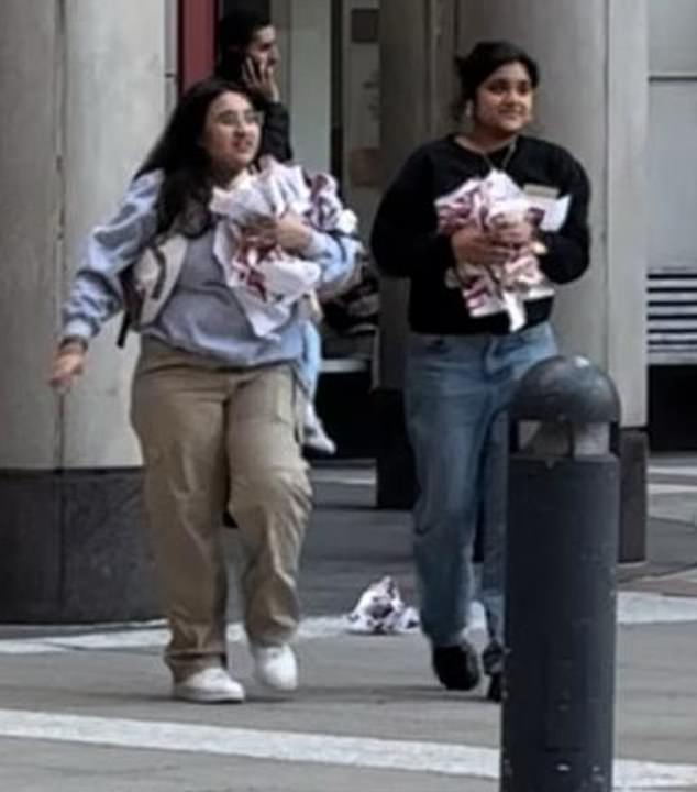 Two female students were seen removing posters of Israeli children taken hostage by Hamas on October 17