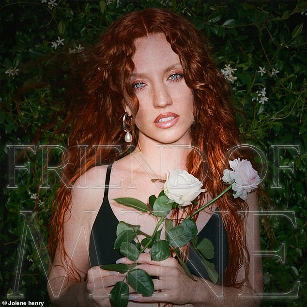 A vision: Her signature red locks were worn in wild curls during the shoot, where she also posed in a cool leather jacket and then a black tank top while holding white roses