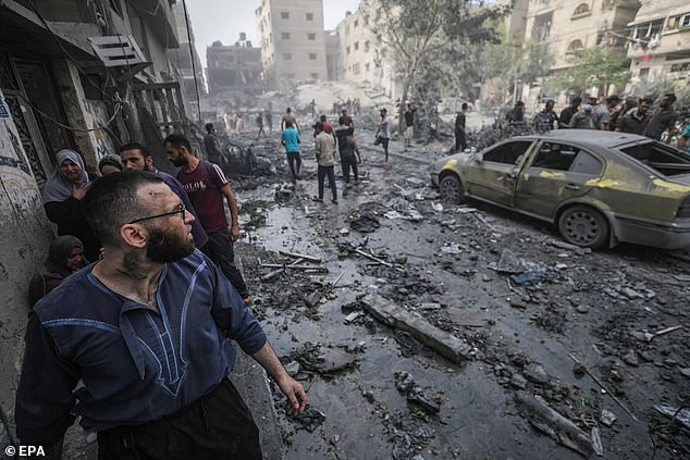 Palestinians inspect a devastated area after Israeli airstrikes in Gaza City, October 23, 2023