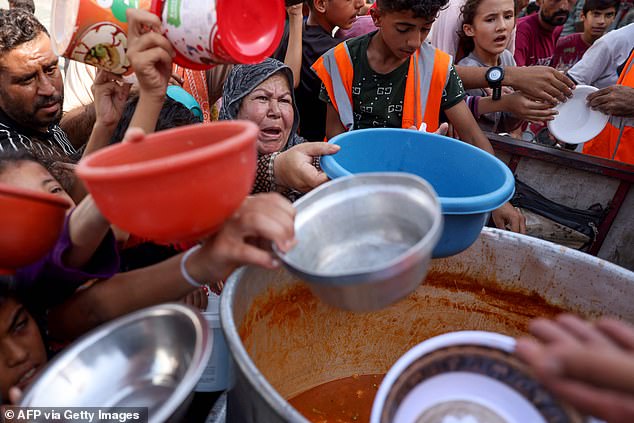 Palestinians receive food at a UN-run school in Rafah, southern Gaza Strip, on October 23, 2023.  Since the start of the war, Israel has cut off the supply of water, electricity, fuel and food to the Palestinian enclave of more than 2 million people