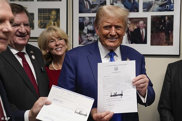 Republican presidential candidate, former President Donald Trump, holds paperwork in New Hampshire on Monday