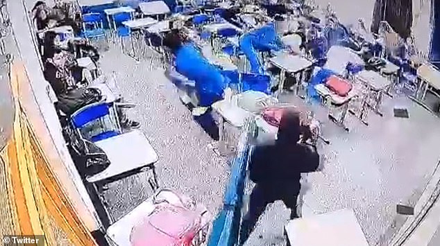 A 16-year-old student stands at the door of a classroom after firing a shot at Sapopemba State School in São Paulo, Brazil, on Monday.  The gunman killed one student and injured two others