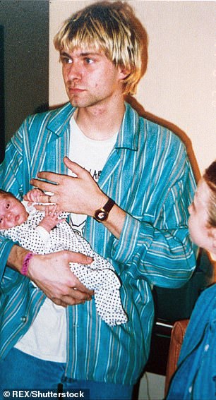 Famous father: Frances is seen in the arms of her late father and Nirvana frontman Kurt Cobain in 1992