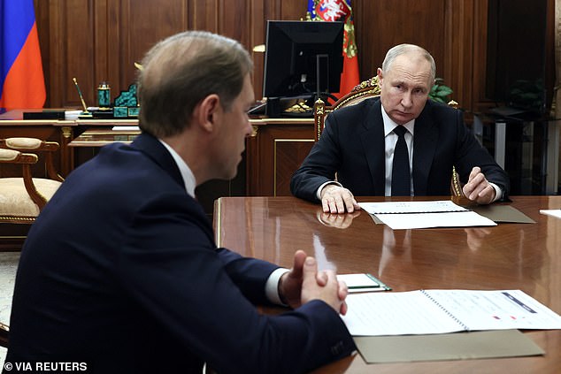 Russian President Vladimir Putin listens to Deputy Prime Minister and Minister of Industry and Trade Denis Manturov during a meeting at the Kremlin in Moscow