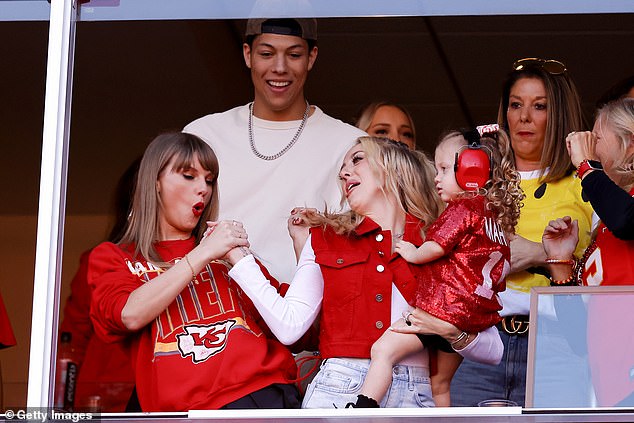 The 33-year-old cheered on Sunday with her new partner's friends and family at Arrowhead Stadium (pictured with Brittany Mahomes)