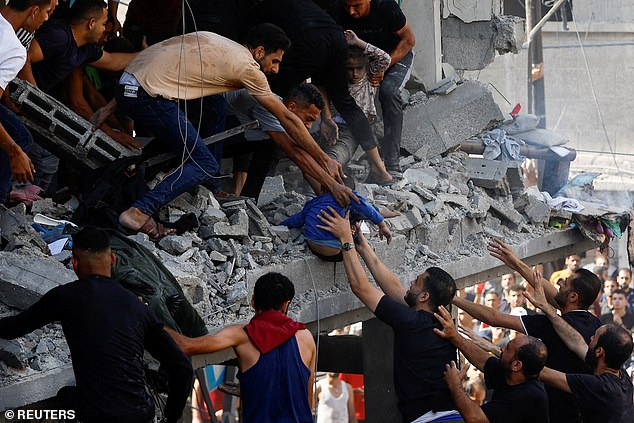 Palestinians carry a small child from the rubble at the site of an Israeli airstrike on October 24.  More than 5,000 Palestinians have been killed since Hamas went to war on October 7