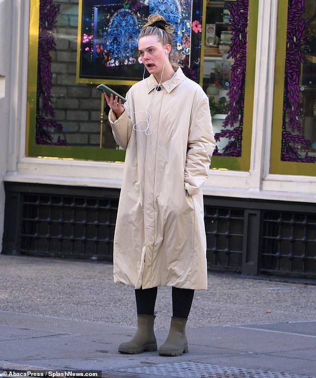 Catching up: The Maleficent star hit the pavement in olive winter boots, perfectly matching her phone case