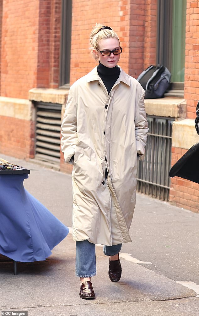 Chic: Hours later, the star was spotted in the same raincoat, but she exchanged her tracksuit for a black turtleneck, wide jeans and patent black loafers