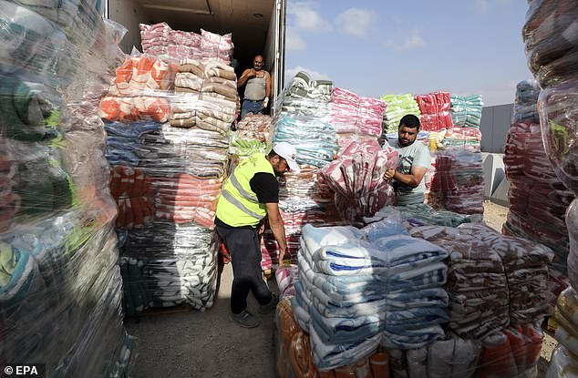 Egyptian volunteers yesterday provide humanitarian aid for Palestinians in the Gaza Strip, at the Rafah border crossing, Egypt