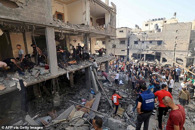 Rescue workers search for survivors in the rubble of a building hit by an Israeli airstrike on October 24 in Khan Yunis in the southern Gaza Strip.
