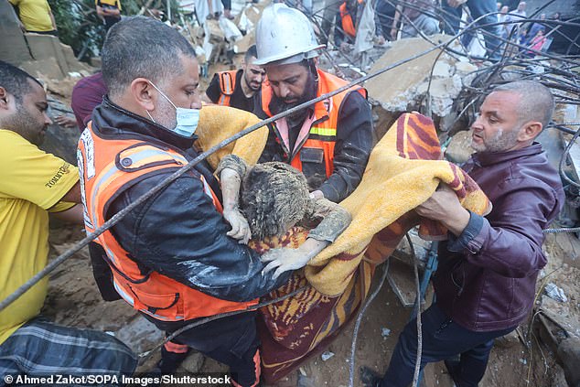 Rescue workers pull a child from the rubble of a building after Israeli attacks in Khan Yunis in the southern Gaza Strip on Tuesday