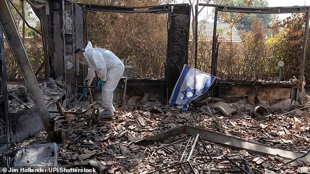 Forensic investigators sift through the rubble of an Israeli house burned to the ground by Hamas