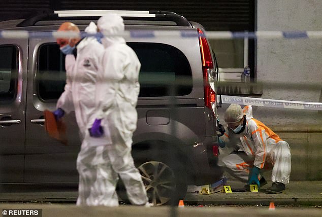 Forensic investigators at the scene in Brussels where two people were shot dead by a gunman