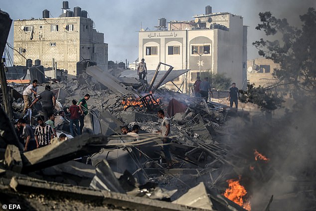 Mr Netanyahu said he would not “not tell” how and when the invasion would take place, nor how extensive it would be.  But last night it was suggested that the planned attack was being shelved at the request of the White House.  The photo shows Palestinians sifting through the rubble in Gaza City on Wednesday