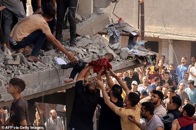 Rescuers pull a child from the rubble of a building hit by an Israeli airstrike in Khan Yunis in the southern Gaza Strip