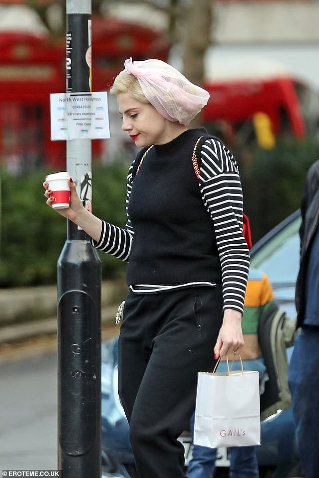 Outfit: Lucy wore a navy blue jacket and added a pair of black boots and a red handbag to her look