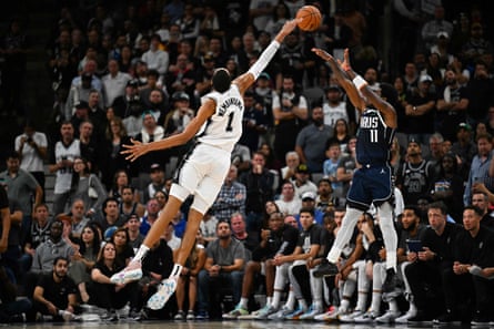 Wembanyama jumps to block a shot from the Mavericks' Kyrie Irving on Wednesday night.