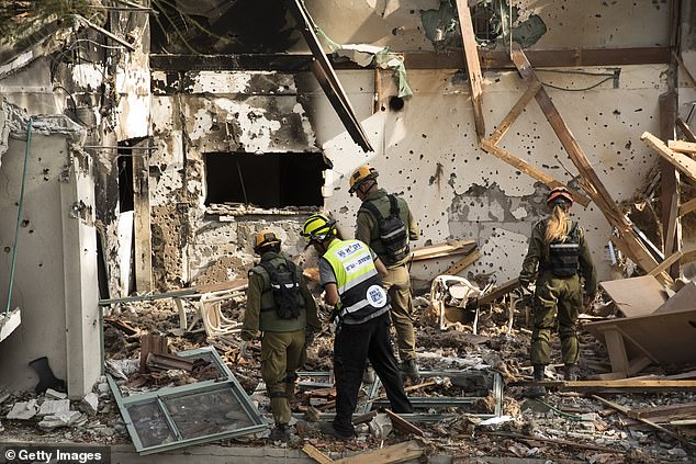 Members of rescue and ZAKA crews search for bodies and body parts after the attack by Hamas and Palestinian militants on the kibbutz on October 22, 2023