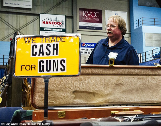 A Maine resident stands at his table during the 2016 gun show held at the Augusta Civic Center in Augusta, Maine