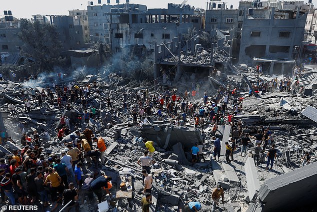 Palestinians search for victims at the site of Israeli attacks on homes as the conflict between Israel and Palestinian Islamist group Hamas continues, in Khan Younis in the southern Gaza Strip, October 26, 2023