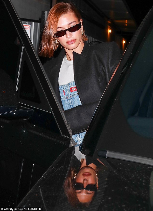 Meanwhile: Hailey wore a scarlet bob as she left church in denim overalls, plus sunglasses after dark