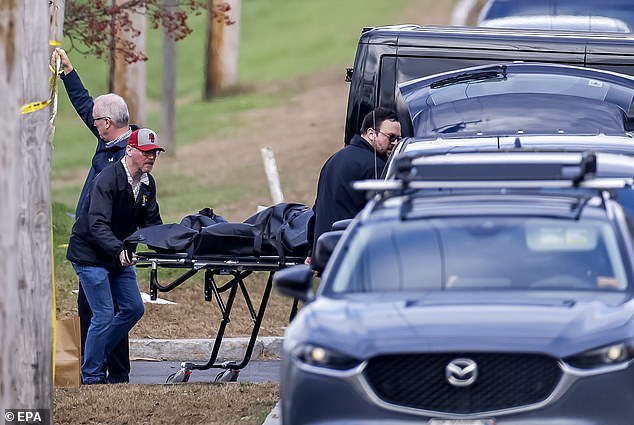 The body of a victim of the Maine shooting that killed at least 18 people has been wheeled out of the bar targeted by the gunman - as police fear he crossed into Massachusetts wearing 