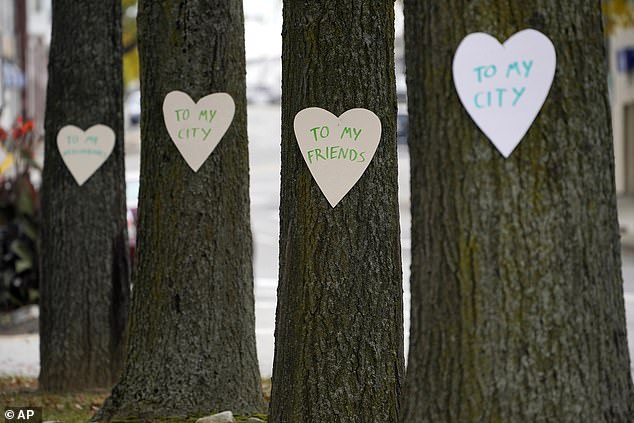 Heart-shaped cutouts with messages of positivity adorn trees in downtown Lewiston, Maine, on Thursday