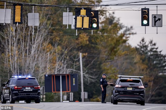 Police check a roadblock during the search for the mass shooting suspect